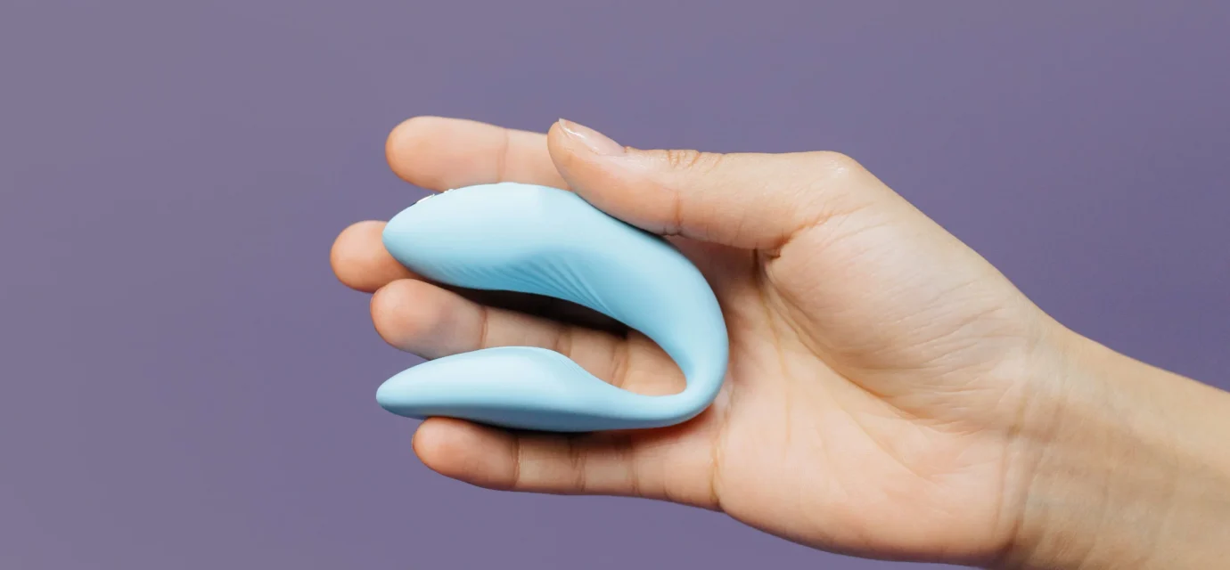A compact blue couples vibrator held in one hand