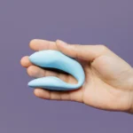 A compact blue couples vibrator held in one hand