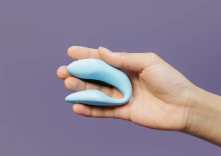 A compact blue couples vibrator held in one hand