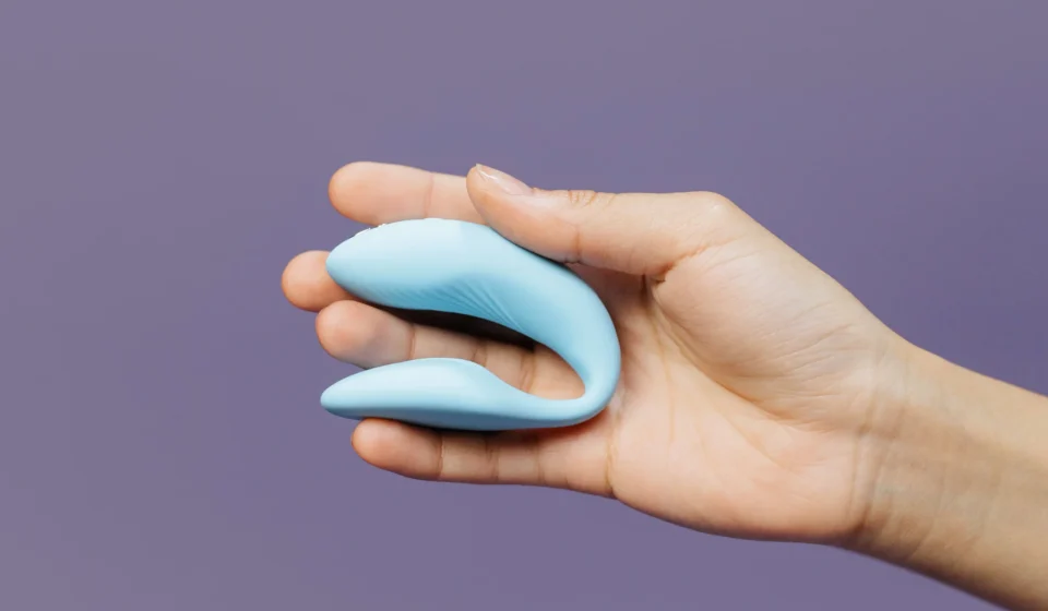 A compact blue couples vibrator held in one hand