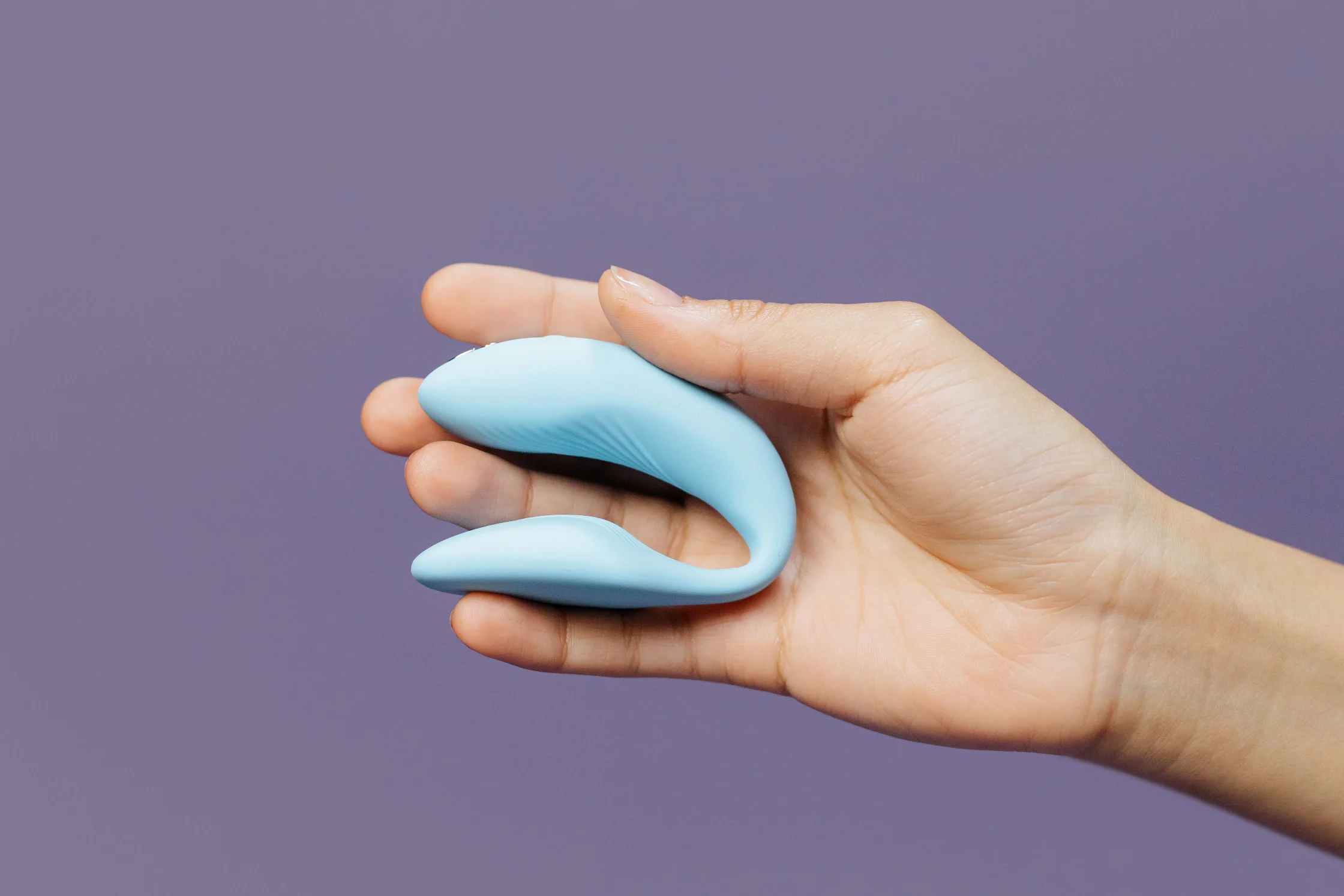 A compact blue couples vibrator held in one hand