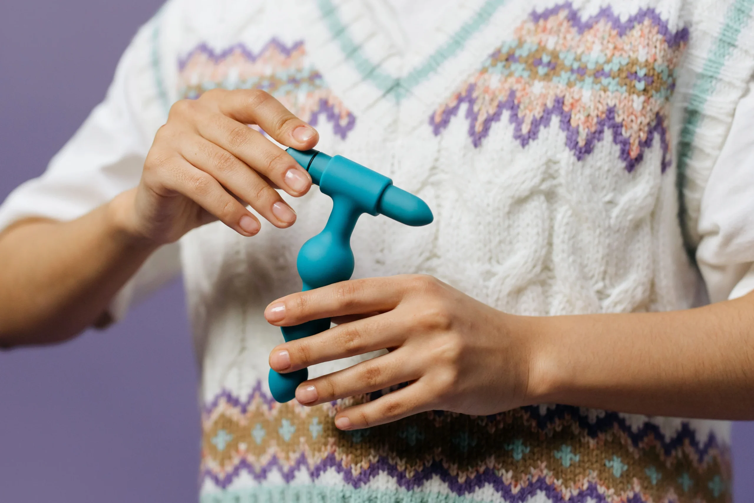 A blue prostate massager being held