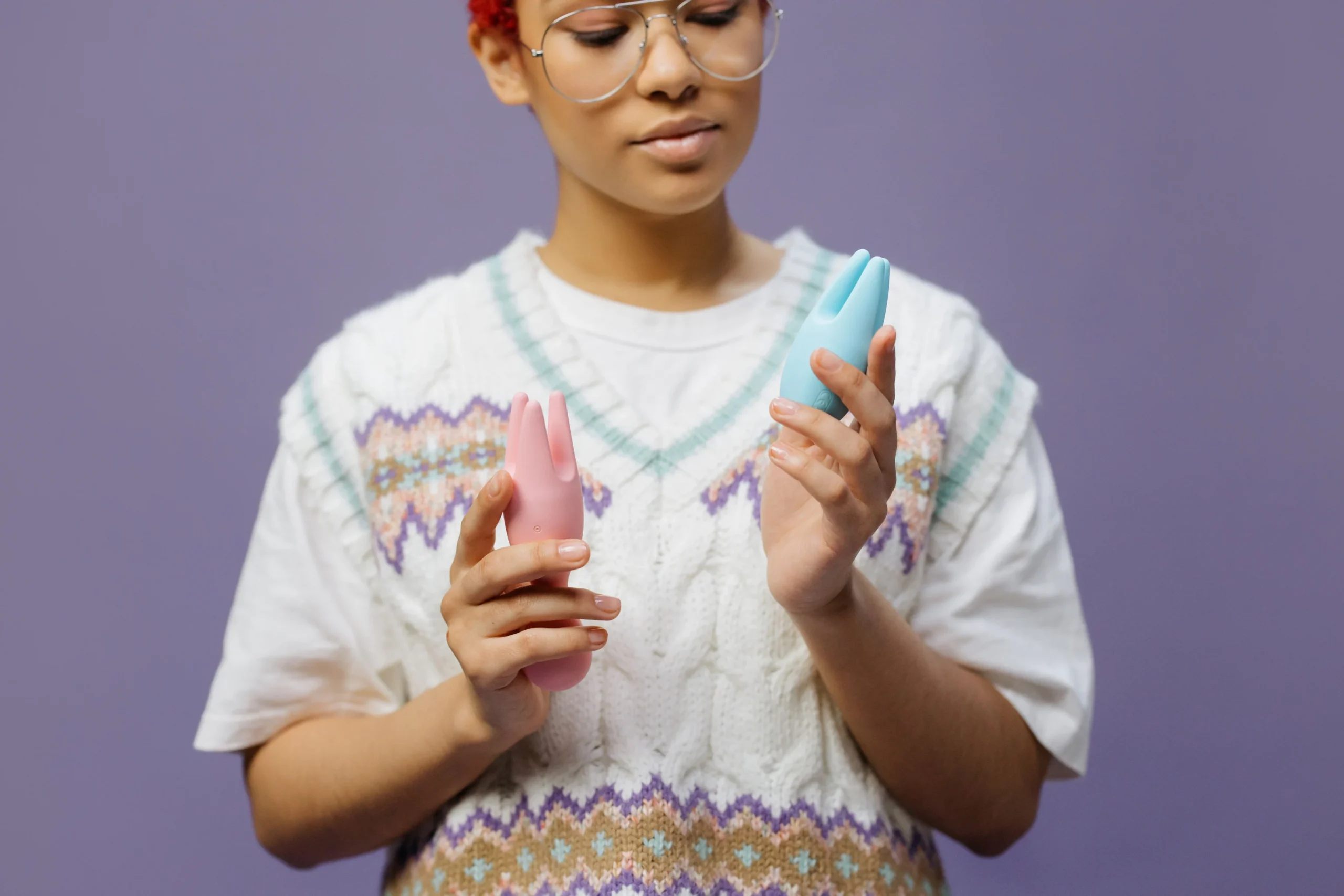 An adult comparing two personal massagers