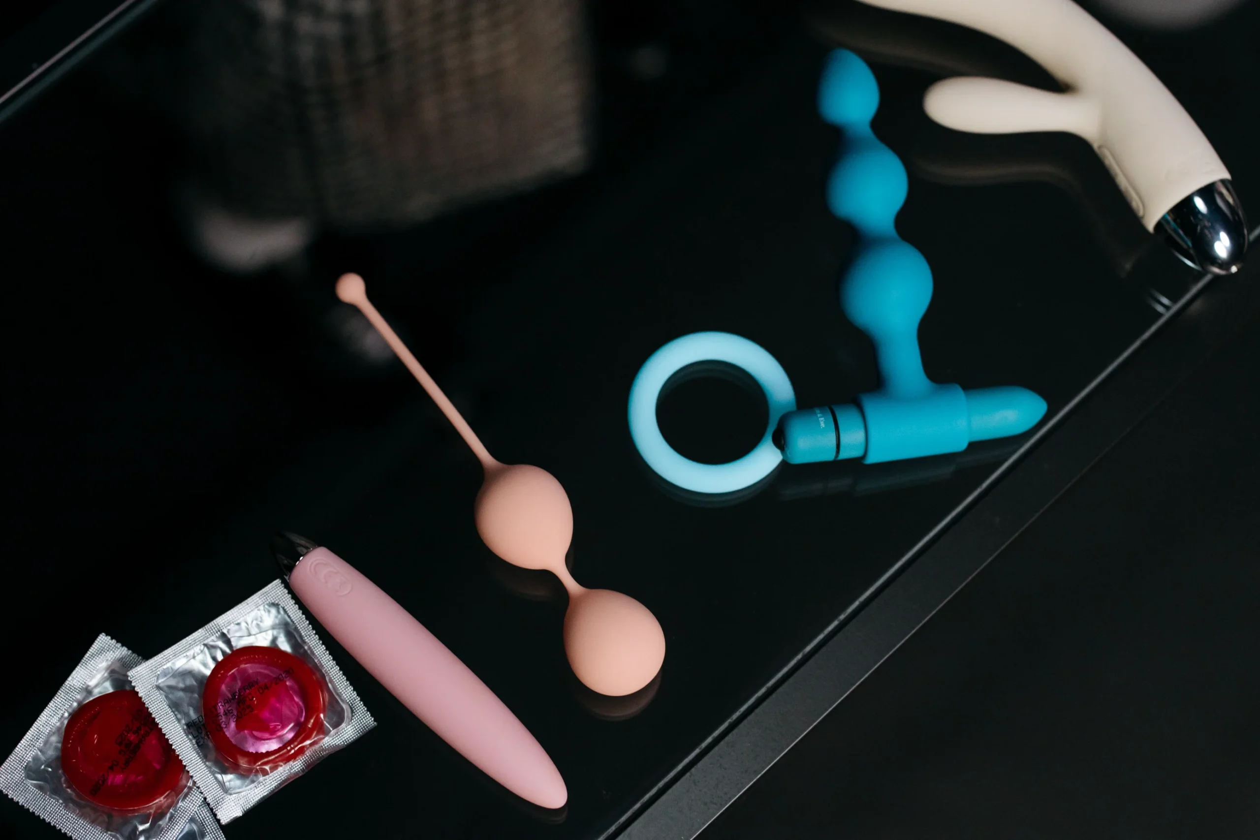 A collection of intimate products arranged on a dark surface